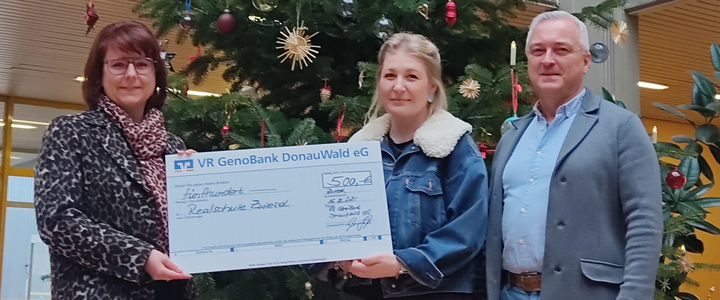 Frau Süß von der GenoBank überreicht den Spendenscheck.